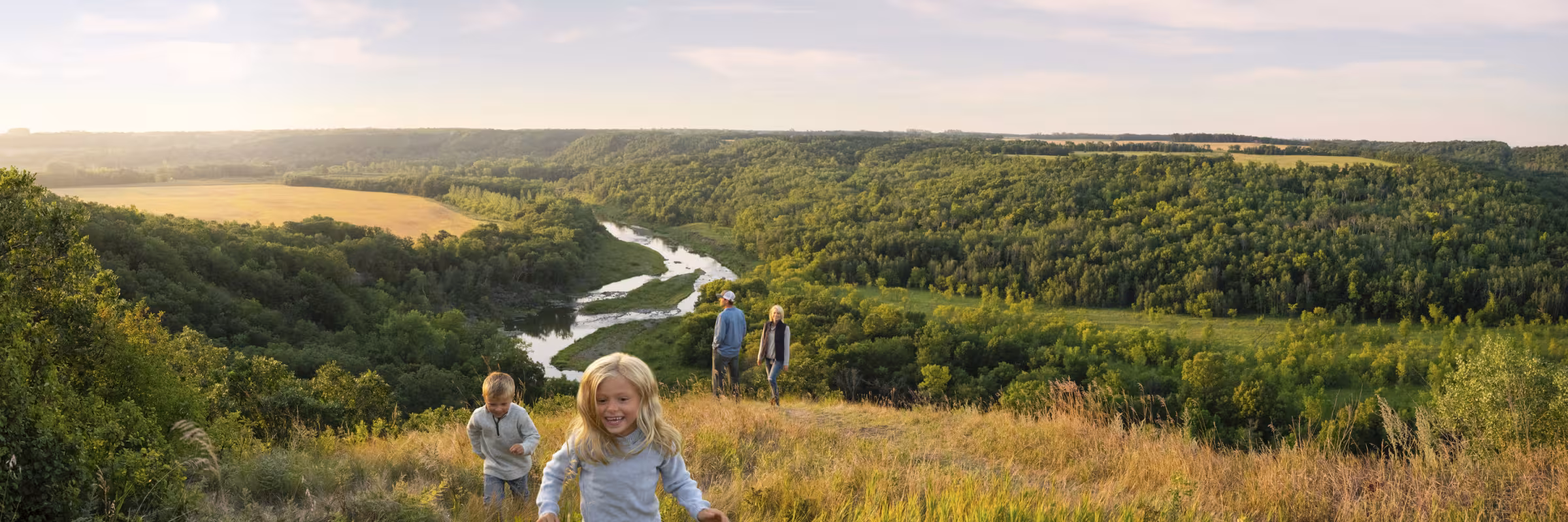 family frolicking in the grass at in ND at sunset