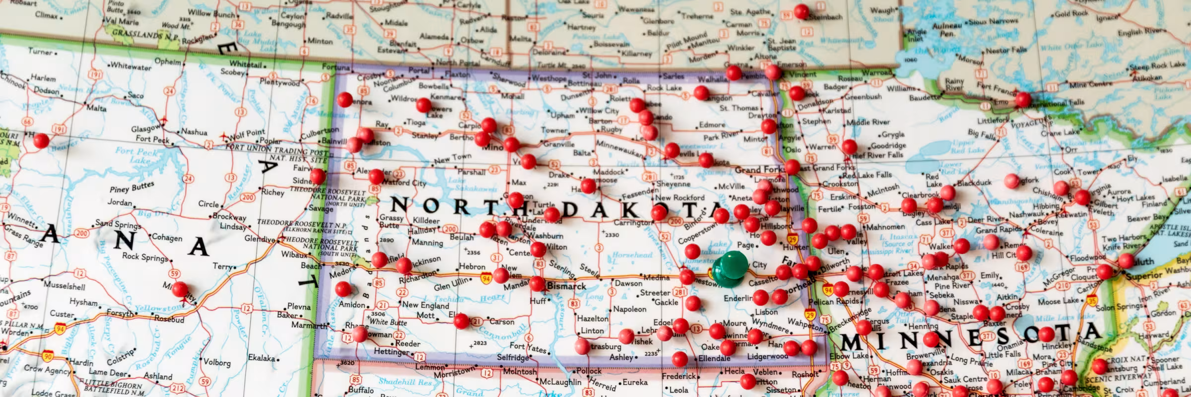 red pins in a paper map showing the Midwest, North Dakota central